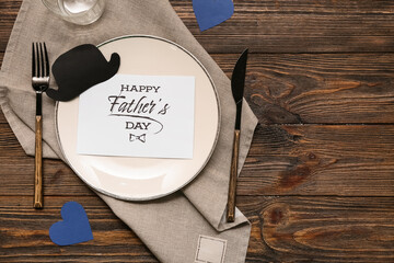 Festive decorated table setting with greeting card on dark wooden background. Father day...