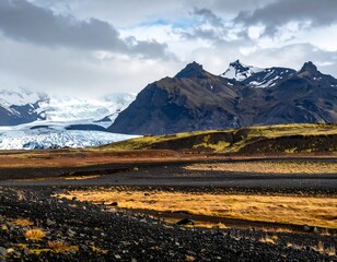 A dramatic landscape featuring a vast, dark, rocky foreground, rolling hills, snow-capped mountains and a glacier. Overcast skies
