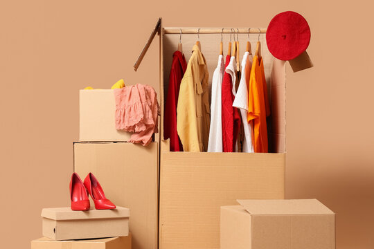 Wardrobe boxes with clothes on beige background