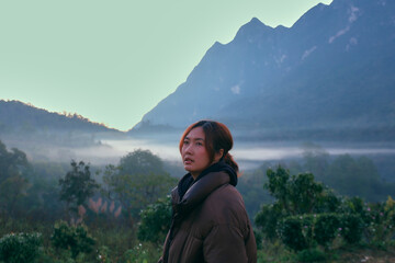 A Thai female tourist is standing and watching the sunrise at Doi Luang Chiang Dao, Chiang Mai Province, Thailand.