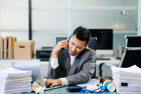 Professional office worker managing phone call and report review simultaneously, showing multitasking and corporate efficiency. - Powered by Adobe