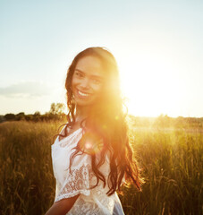 Sunshine, happy and portrait of woman in field for fresh air, holiday and adventure in morning. Nature, flare and person in countryside for tourism, travel and relax outdoor for peace, calm and smile