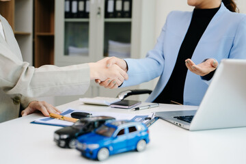 Car saleswoman handing over car key to customer at showroom. Vehicle purchase, auto finance, contract signing and successful car sales business concept.