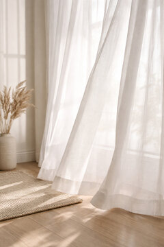 White sheer curtains gently blowing in sunlight, creating a serene and airy atmosphere in a room with a wooden floor and pampas grass.