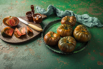 Large black tomato on a green vintage background