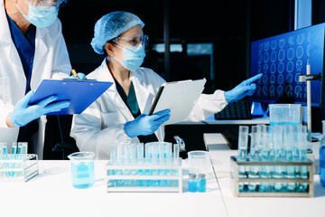 Medical scientists conducting laboratory research using digital tools and lab equipment. Healthcare, biotechnology, diagnostics, and clinical research teamwork concept.
