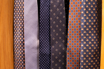 Ties in various designs. Choosing classic tie. Unusual designs for shirt accessories. Premium ties hang in clothing store. Buying tie to match your shirt. Choose your tie in business and casual style
