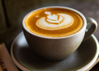 Hot cup of coffee latte with beautiful leaf pattern latte art