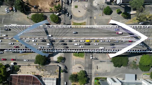 Dynamic aerial view of Matute Remus Bridge, Guadalajara. Modern architecture with busy traffic on bridge lanes and city streets on a sunny day