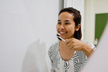 Woman brushing her teeth in the morning.