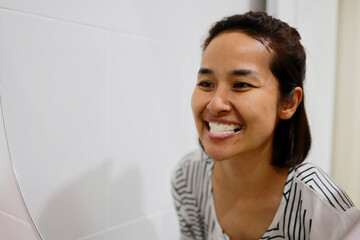 Woman brushing her teeth in the morning.