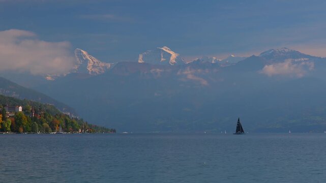 Sailboats boat Swiss Alps Grindelwald Jungfrau mountains Bernese Oberland Thunersee Lake Thun Flusswelle Aare River aerial drone Thun Switzerland Schweiz Fall Autumn sunny morning clouds Interlaken