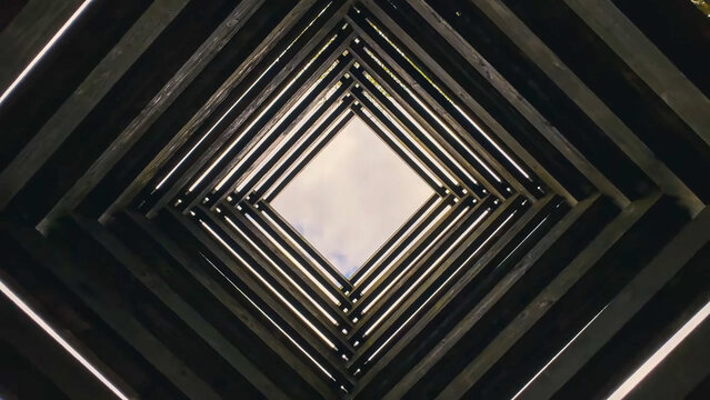 Upward perspective of a square wooden geometric skylight structure