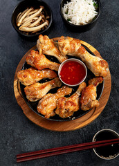 Baked chicken wings in asian style with sauces.