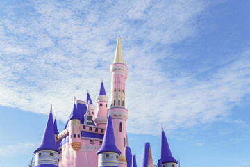 ronda,malaga,spain Bright pink fairytale castle with purple spires reaching into a cheerful blue sky with scattered white clouds, evoking fantasy and childhood