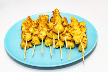 Chicken skewers with golden marinade displaying grilled marks, a popular appetizer or main course from asian cuisine