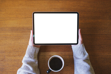 Top view mockup image of a woman holding digital tablet with blank white desktop screen in cafe