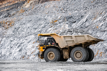 Big yellow Mining Dump Truck in Action at Rocky ore Quarry © Parilov