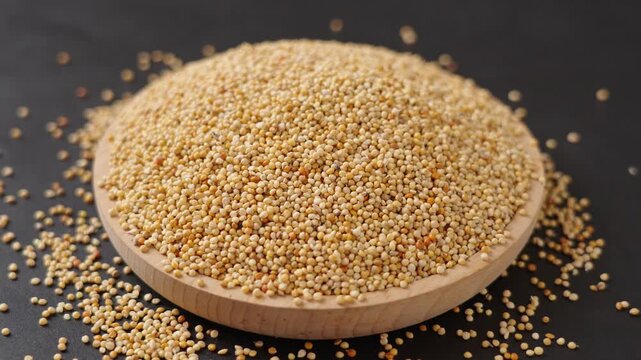 unpeeled millet grain on black background