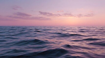 Serene ocean surface reflecting pastel pink and purple sky at dawn or dusk