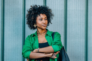 young woman with afro hair on a street wall with copy-space