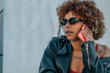 black african american girl talking on mobile phone or smartphone in the street outdoors