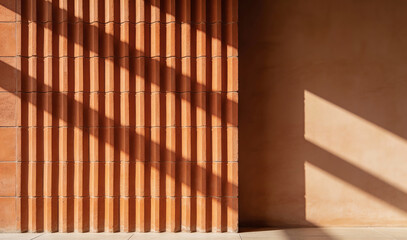 Minimalist terracotta wall with vertical slats and dramatic sunlight casting geometric shadows