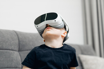 Young caucasian boy with vr headset exploring virtual reality at home