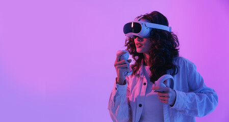 Young asian female gamer engaged in virtual reality gaming with headset and controllers. Concept gaming immersive technology