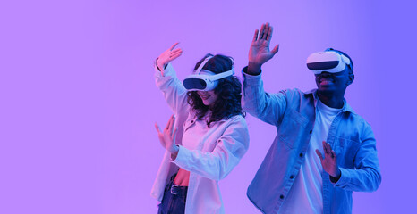 Immersive fashion digital and futuristic innovation concept. Young multiethnic team adults experiencing virtual reality with headsets in neon lighting
