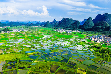 Beautiful green rice fields and village with karst mountain natural landscape in Guilin, China.