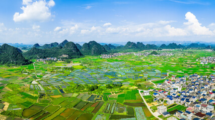 Beautiful green rice fields and village with karst mountain natural landscape in Guilin, China.