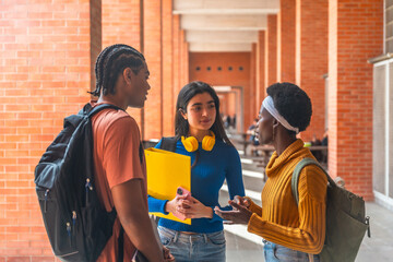 Diverse students conversing in university campus hallway