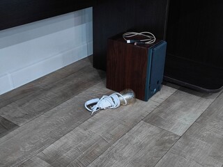 Speaker amplifier and light bulb on the wooden floor. Electronic items and accessories, home electronics. Audio reproduction for devices.