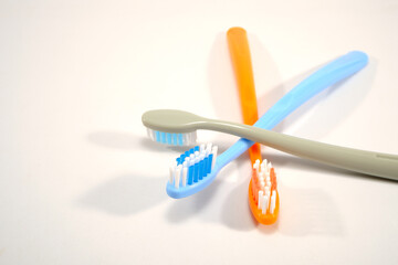 Vibrant toothbrushes pairing together on a sleek white background with copy space, evoking a sense of cleanliness and oral health, Daily routine concept photography