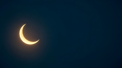 Crescent moon shining brightly in dark night sky