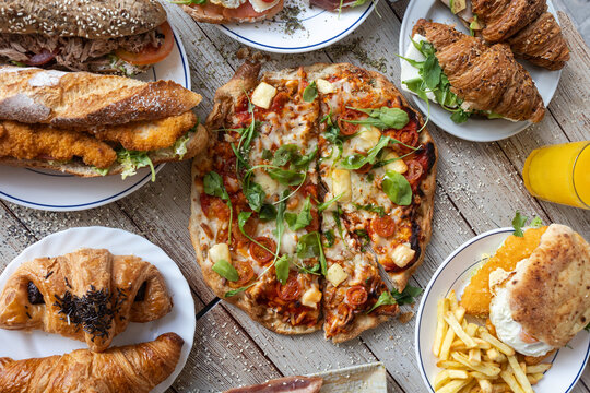 Delicious brunch spread with pizza, sandwiches, and pastries