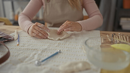 Woman hands shaping clay in a ceramics studio; creativity calm focus.
