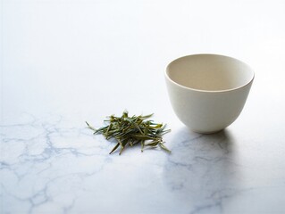 Tea leaves and empty white ceramic cup on marble surface