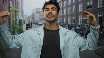 Man gesturing with hands on bustling urban street flanked by brick buildings and parked bicycles; enthusiastic communication.