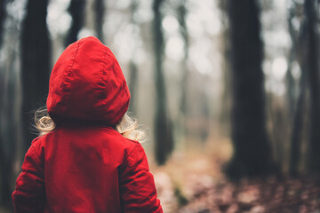 Young girl in red coat in forest