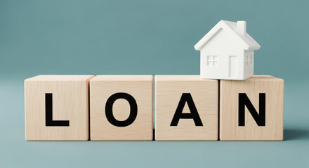 Wooden blocks spelling loan with a small white house model on top, symbolizing home financing and mortgage concepts in a modern financial context