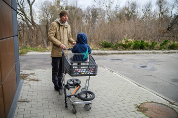 Father and son spending time together during a winter grocery trip, walking with a shopping cart, sharing snacks, and enjoying everyday family moments outdoors near a store.