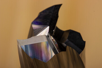 cutting edge of a spiral wood milling cutter in close-up on a light wooden background. spiral carbide milling cutter. cnc tool.