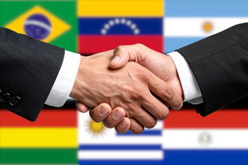 Flags of the Mercosur countries and a handshake as a symbol for the conclusion of a contract