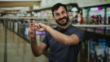 Man gesturing hashtag in a bustling shopping mall, highlighting hispanic ethnicity, with a beard,...