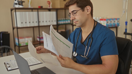 Man doctor reading medical papers and holding documents with stethoscope visible in clinic; calm focus.