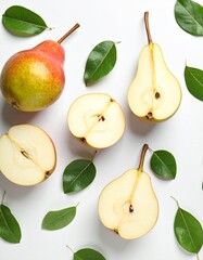 Fresh pears and green leaves arranged on a white surface, a beautiful food composition.