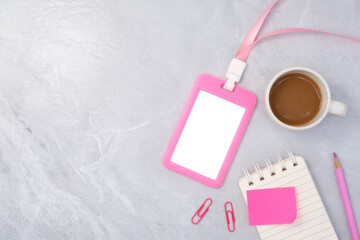 Pink plastic badge with book and coffee on white stone texture background. Template designed for employees of company