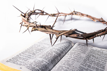 Crown of thorns resting on open holy book, symbolizing sacrifice, salvation, and christ's suffering